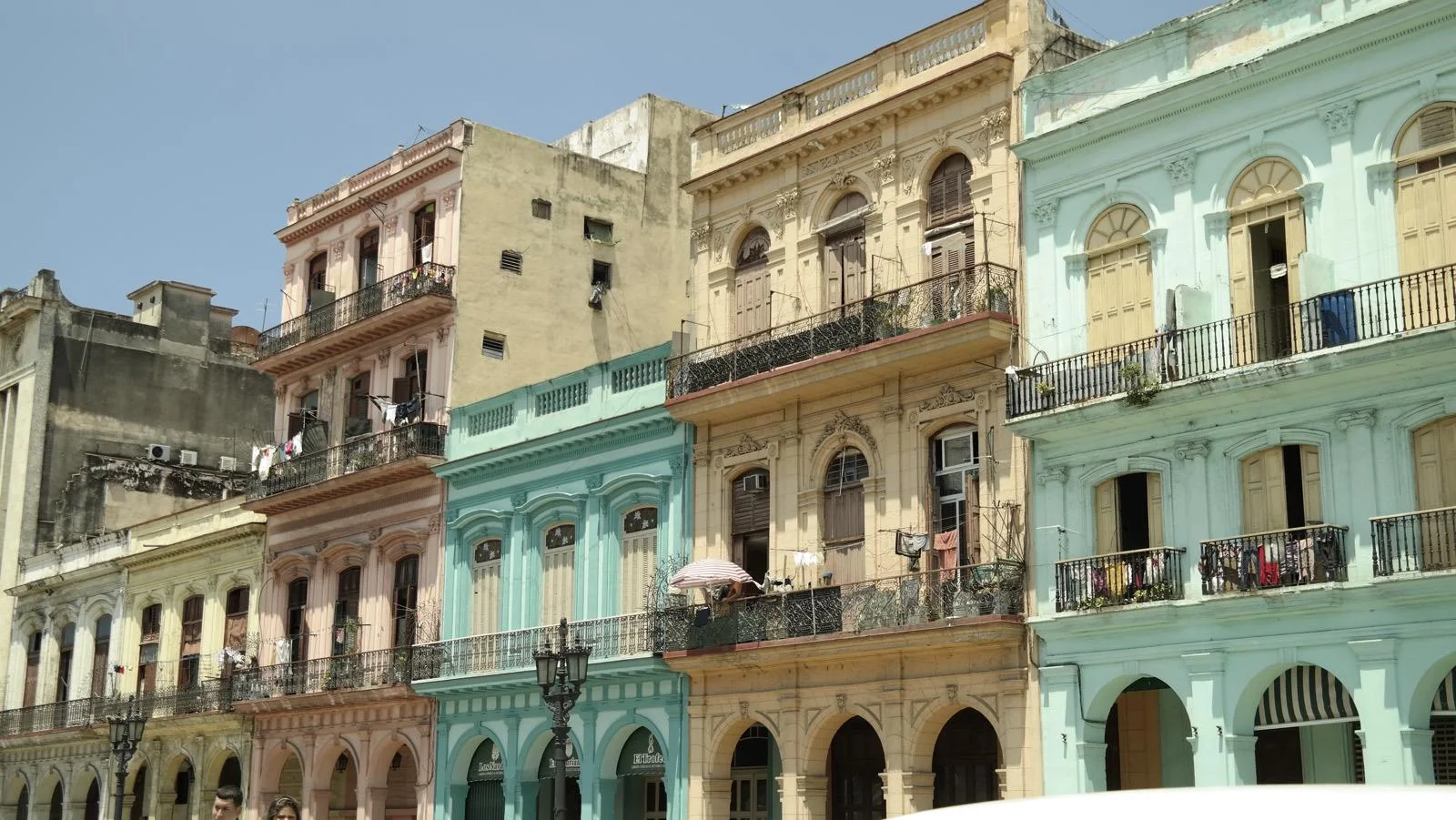 A row of pastel colonial facades with iron balconies in Havana