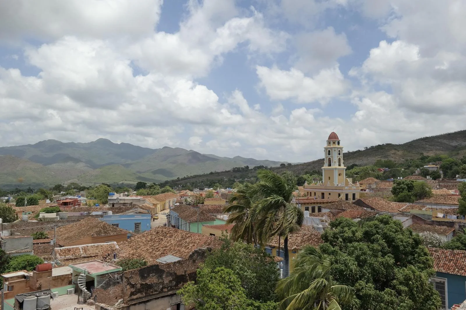 The tiled rooftops of Trinidad, its yellow bell tower and the Escambray mountains behind
